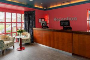 戈尔韦斯格芬顿亚姆斯酒店的一间设有红色墙壁的等候室,设有前台