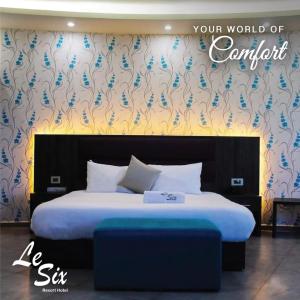 拜特龙Le Six Hotel And Resort的一间卧室,配有一张墙上的蓝色花卉床