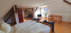 SchadelebenPension Robinienhof的卧室配有一张床和一张桌子及椅子