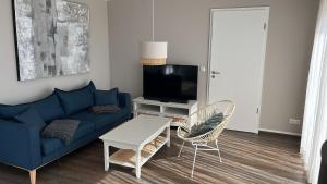 LöbnitzFerienhaus Jonas的客厅配有蓝色的沙发和电视