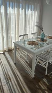 LöbnitzFerienhaus Jonas的一张带两把椅子的白色桌子和一张玻璃桌