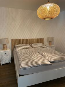 LöbnitzFerienhaus Jonas的一间卧室配有一张床和一个吊灯