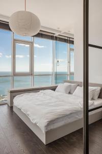 敖德萨Sea and Sky Apartment的卧室设有一张带窗户的白色大床