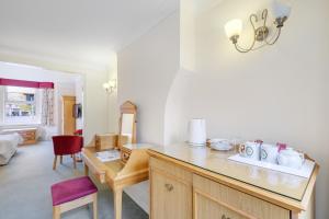 温莎Charles House - Windsor Castle的厨房配有书桌和红色椅子