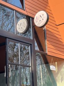 甲米镇Infinite Resort and Cafe的两把钟,在一栋带窗户的建筑的一侧
