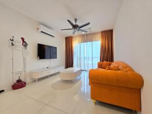Kampong PinjiManhattan Condominium - Jalan Pasir Puteh - Ipoh的客厅配有橙色沙发和平面电视。