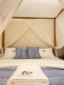 NgurblutJOSEPHA COTTAGE的帐篷内的一张带蓝色和白色枕头的床