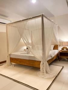 NgurblutJOSEPHA COTTAGE的卧室配有带蚊帐的天蓬床