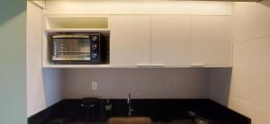 萨尔瓦多COSTE0104 - Premium Stella Maris的一间厨房,厨房内配备了白色橱柜内的微波炉