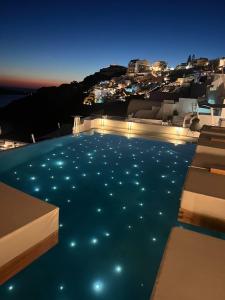 伊亚La Perla Villas and Suites - Adults Only的夜间水中灯光的游泳池