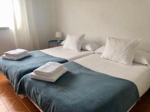 卡里尼奥Vivienda de Uso Turístico Cariño的两张床并在一起,配有毛巾