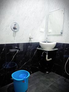 埃尔加德R Hotels By Suraj Residency Yercaud的浴室设有水槽、镜子和水桶