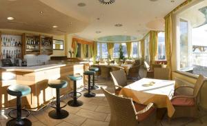 福姆普Hotel Vomperhof的餐厅设有酒吧和桌椅