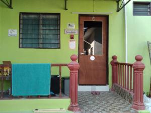 Pasir MasPutat Gajah Villa PASIR MAS的绿色的房子,设有木门和阳台