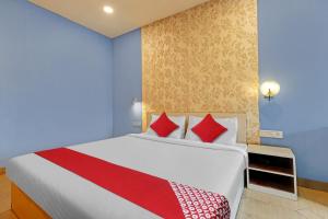 KāhārpāraOYO Flagship 81041 New Jebiis Inn的卧室配有带红色枕头的大型白色床