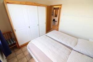 库克斯港Horizont-Wohnung-3的卧室配有白色的床和白色橱柜。