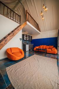 萨潘贾SNAİL HOUSE SAPANCA的客厅配有橙色家具和楼梯