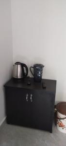 马迪凯里Katakeri Deluxe Holiday Homes的黑色橱柜,上面有茶壶