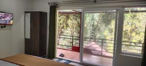 马迪凯里Katakeri Deluxe Holiday Homes的卧室设有窗户,享有门廊的景色