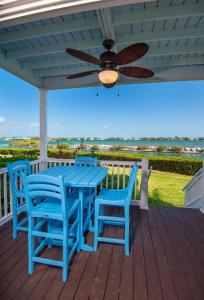 马拉松老鹰岩礁度假酒店的甲板上配有一张蓝色的桌子和椅子,配有吊扇