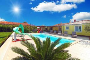 罗波里卡Ferienhaus mit Privatpool für 8 Personen ca 130 qm in Loborika, Istrien Südküste von Istrien的一座房子旁边的游泳池,带滑梯