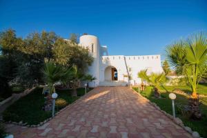 塔格梅斯Menzel Troguet, Dream House in Djerba的一条通往白色树木建筑的道路