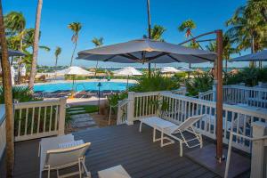 马拉松老鹰岩礁度假酒店的一个带椅子和遮阳伞的甲板和游泳池
