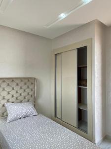 胡塞马Mini villa Al hoceima的一间卧室配有一张床和一个带镜子的橱柜