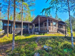 萨翁林纳Villa Kolovesi - Saimaa Retreat的树林里的一个大型小木屋,有一个院子