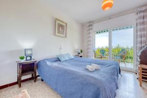 罗萨斯Corsario Roses Almadrava - Barneda的一间卧室设有蓝色的床和窗户。