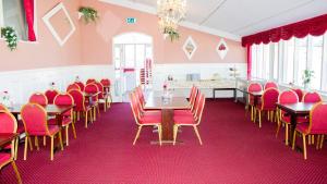 海泽胡瑟讷A Hotels Roskilde的用餐室配有红色椅子和木桌