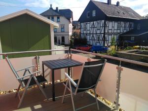 巴特马林贝格Ferienhaus in Bad Marienberg Westerwald mit Grill und Terrasse的阳台配有两把椅子和一张桌子,位于屋顶
