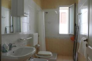 萨尔维La Villa的一间带水槽和卫生间的浴室以及窗户。