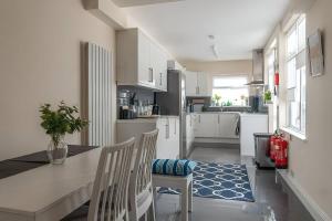 伦敦Beautiful and spacious home的厨房配有白色橱柜和桌椅
