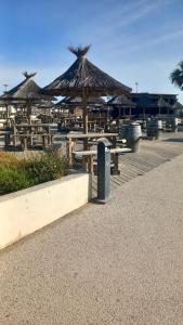 塞特港mobil home le castellas Bertrand /stehlin的海滩上一组带遮阳伞的野餐桌