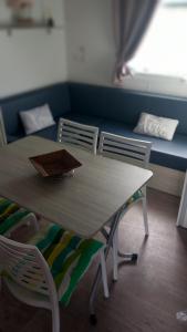 塞特港mobil home le castellas Bertrand /stehlin的一张桌子和椅子,位于一个配有沙发的房间