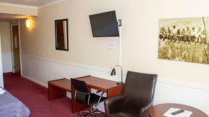 海泽胡瑟讷A Hotels Roskilde的客房设有书桌、两把椅子和一张床