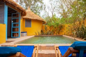 巴马科坎配门山林小屋的一个带两把椅子的游泳池以及一座房子