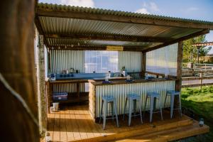 马拉费尔特Rosgarron Safari Canvas Lodge Glorious Glamping的甲板上的酒吧,四周有凳子