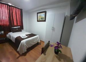 卡哈马卡Hotel Los Reyes的一间卧室配有一张床和一张鲜花桌