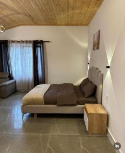 斯库台Qyteza Guest House & Camping的一间卧室配有一张床和一张沙发