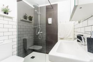 波多·纳奥斯Apartamento Daniella的白色的浴室设有水槽和淋浴。