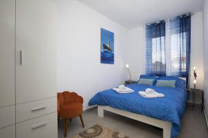 罗波里卡Villa Kostre的一间卧室配有蓝色的床和毛巾