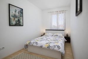罗波里卡Villa Kostre的白色的卧室设有床和窗户