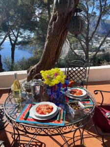 卡普里Villa Guya的一张带食物盘的庭院桌子