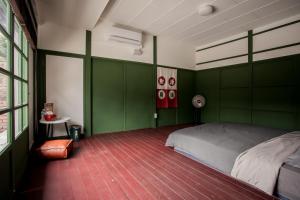 高雄兴华居室的一间拥有绿色墙壁的卧室,其中配有一张床