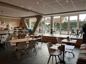 奥特马瑟姆Villavelo Twente的餐厅设有桌椅和窗户。