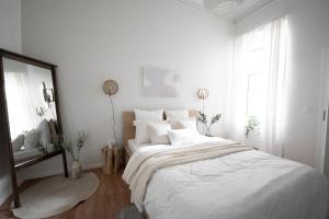 卢森堡Stockholm Style Designer in Limpertsberg ID8的白色卧室设有一张大床和镜子