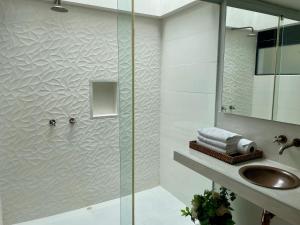 阿纳波伊马拉玛西亚精品酒店的带淋浴、水槽和镜子的浴室