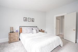 卡温顿Kentucky Ave - Heart of Mainstrasse的白色卧室配有白色的床和木制床头柜